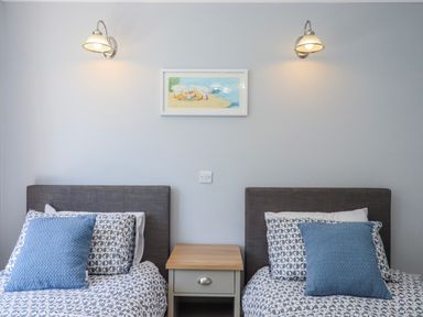 A bedroom with two beds and a nightstand at The Arches in Torquay
