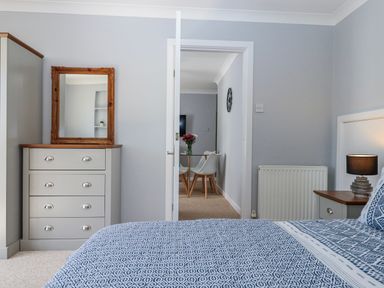 A bedroom with a dresser and a mirror at The Arches in Torquay