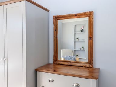 A bedroom with a mirror and wardrobe at The Arches in Torquay