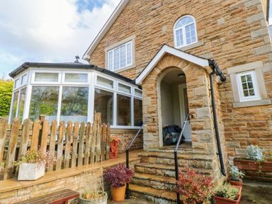 An outdoor view of a house entrance with a garden at Stone Lodge near Haltwhistle
