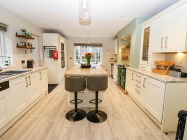 A kitchen with an island and bar stools at Stone Lodge near Haltwhistle