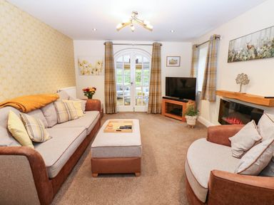 A living room with a sofa and television at Stone Lodge near Haltwhistle