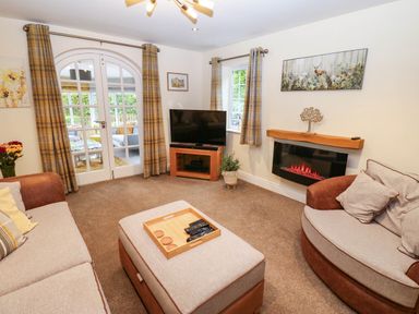 A living room with a television and a coffee table at Stone Lodge near Haltwhistle