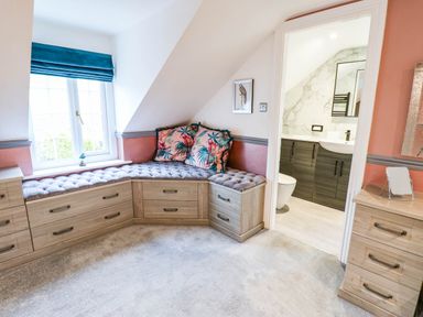 A bedroom with a seating area and a bathroom door at Stone Lodge near Haltwhistle