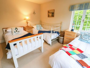 A bedroom with three beds and a lamp at Stone Lodge near Haltwhistle