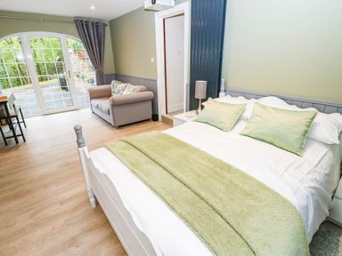 A bedroom with a bed and sofa at Stone Lodge near Haltwhistle