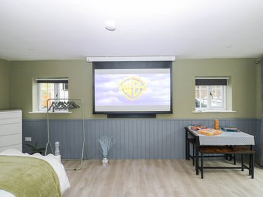 A snug with a projection screen and table at Stone Lodge near Haltwhistle