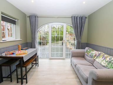 A snug room with a sofa and dining table at Stone Lodge near Haltwhistle