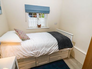 A bedroom with a bed and a window at Stone Lodge near Haltwhistle