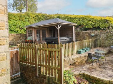 A garden with a shed and hot tub at Stone Lodge near Haltwhistle