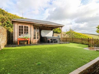 A garden with a shed and patio area at Stone Lodge near Haltwhistle