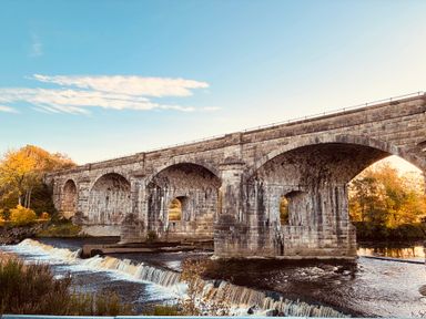 A stone bridge over a river with trees nearby at Stone Lodge near Haltwhistle