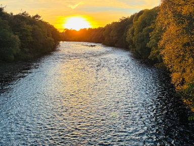 A river with trees beside it and a sunset at Stone Lodge near Haltwhistle