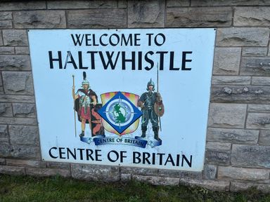 A welcome sign for Haltwhistle, Centre of Britain