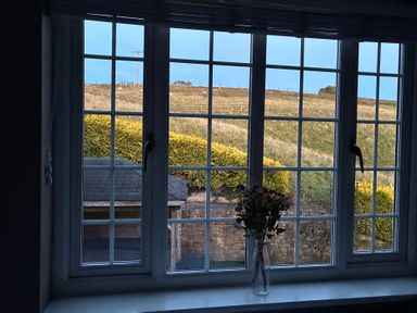 A window view showing a garden and a hill at Stone Lodge near Haltwhistle