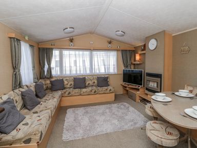 A living room with a sofa and television at Ger Y Mor in New Quay