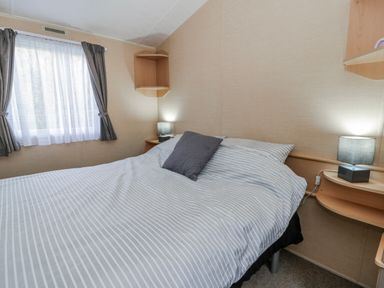 A bedroom with a bed and lamps at Ger Y Mor in New Quay