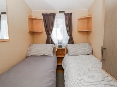 A bedroom with two beds and shelves at Ger Y Mor in New Quay