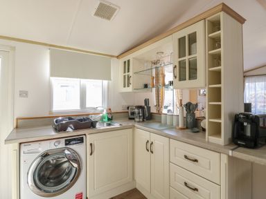 A kitchen with a washing machine and sink at 2 bed Caravan Stowmarket