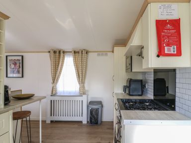 A kitchen with a window and a fire blanket at 2 bed Caravan Stowmarket