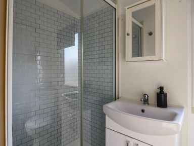 A bathroom with a shower and sink at 2 bed Caravan Stowmarket