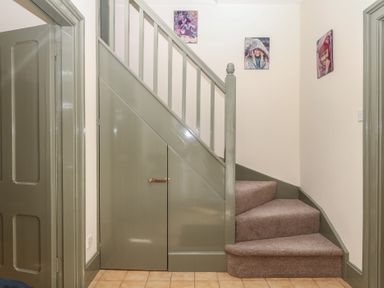 A staircase with photographs on wall at Lukesland Wing Ivybridge