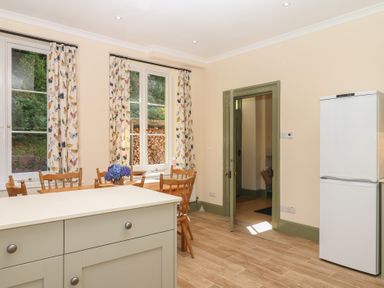 A kitchen with a table and chairs at Lukesland Wing in Ivybridge