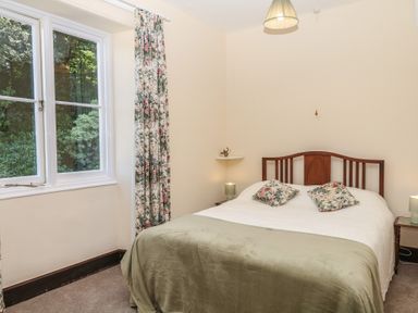 A bedroom with a bed and window at Lukesland Wing in Ivybridge