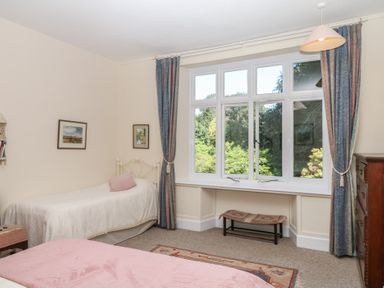 A bedroom with two beds and a window at Lukesland Wing Ivybridge