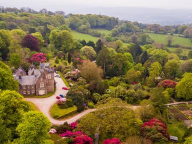 A house surrounded by trees and flower beds at Lukesland Wing near Ivybridge