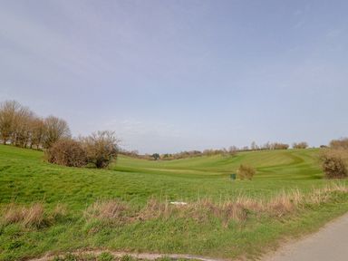 A view of a golf course with hills and trees at The Coach House Dorchester