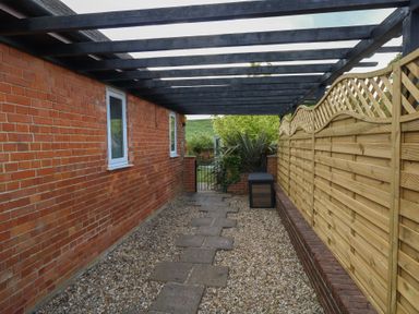 An outdoor space with a path and fencing at The Coach House Near Charminster