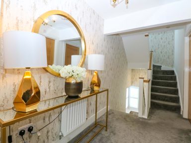 A hallway with a console table, lamps and mirror at 2 Glan Yr Aber, Colwyn Bay