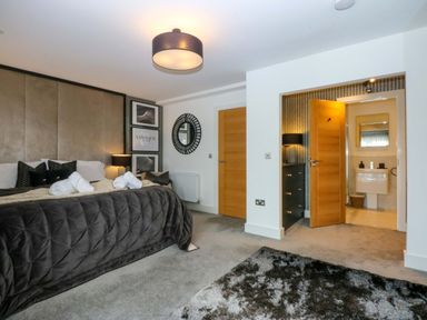 A bedroom with a bed and an ensuite bathroom at 2 Glan Yr Aber in Colwyn Bay