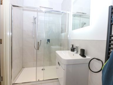 A bathroom with a shower, toilet, and sink at 2 Glan Yr Aber, Colwyn Bay