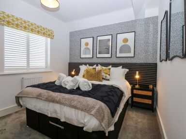 A bedroom with a bed and wall art at 2 Glan Yr Aber in Colwyn Bay