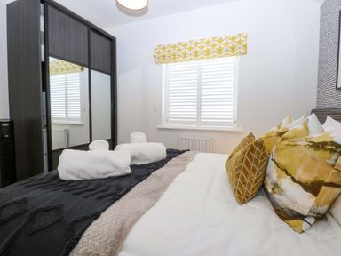A bedroom with a bed and wardrobe at 2 Glan Yr Aber in Colwyn Bay