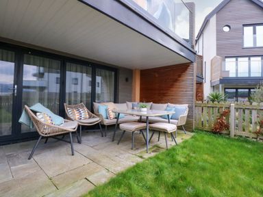 A patio area with seating and a table at 2 Glan Yr Aber in Colwyn Bay