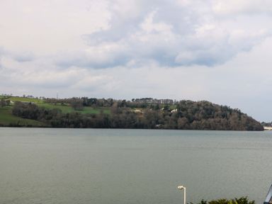 A view of water and land with trees and buildings at 2 Glan Yr Aber Colwyn Bay