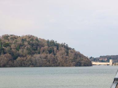 A view of a hill and a bridge over the water at 2 Glan Yr Aber in Colwyn Bay