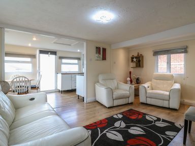 A living room with white chairs and a table at 130 Park Ave Holiday Village
