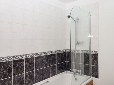 A bathroom featuring a bathtub and shower enclosure at The Cottage in Sampford Courtenay