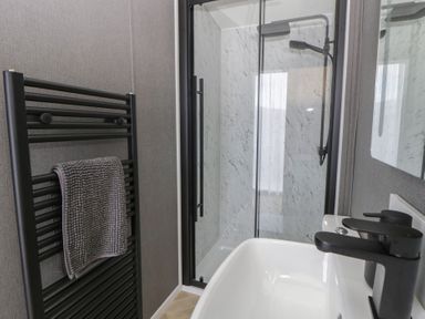 A bathroom with a shower and sink at Dawn's Rest Nantmel near Rhayader