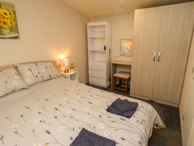 A bedroom with a bed and wardrobe at Gardeners Lodge in 