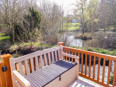 A bench overlooking water and trees at Gardeners Lodge 