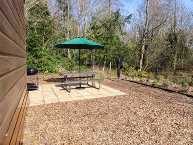 An outdoor area with a table and umbrella at Gardeners Lodge in 