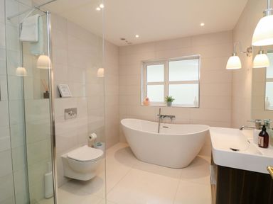 A bathroom with a bathtub, shower, sink, and toilet at Sunnyside in River Chapel