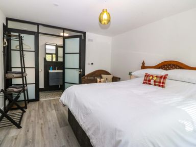 A bedroom with a bed and wardrobe at Trwyn Cam Brynrefail near Llanberis