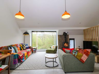 A living room with a sofa and coffee table at Trwyn Cam in Brynrefail near Llanberis