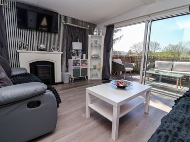 A living room with a fireplace and television at Grosvenor 10 in Llanarmon-Yn-Ial